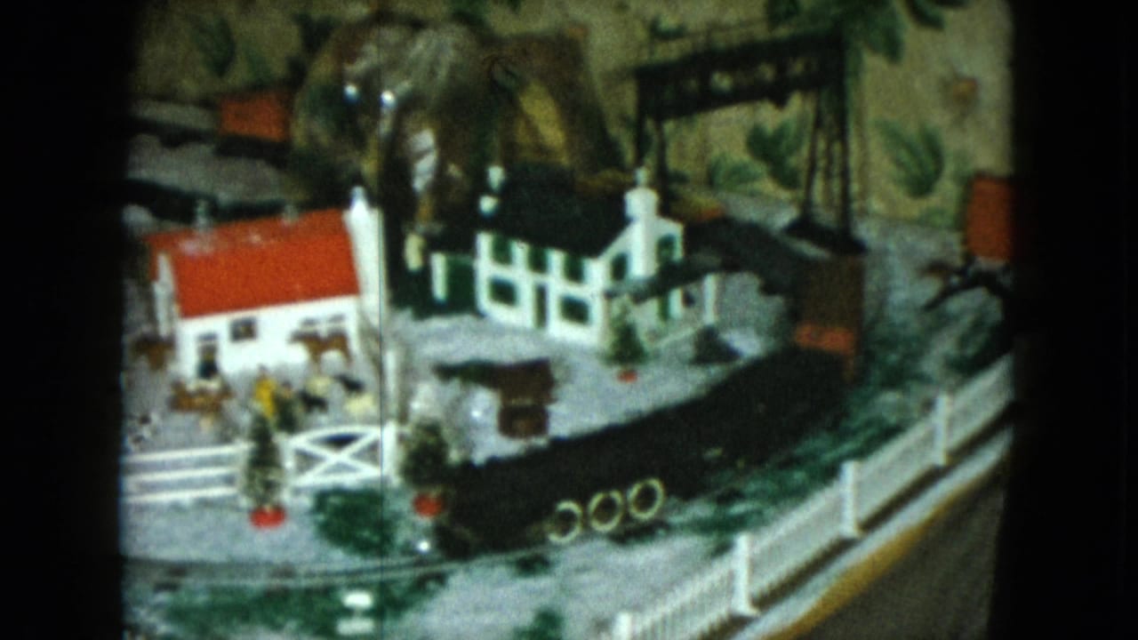 1951 Cleveland frame showing a wider tabletop railroad town with a church, red-roofed house, bridge, fence, curved track, and small scenery pieces.