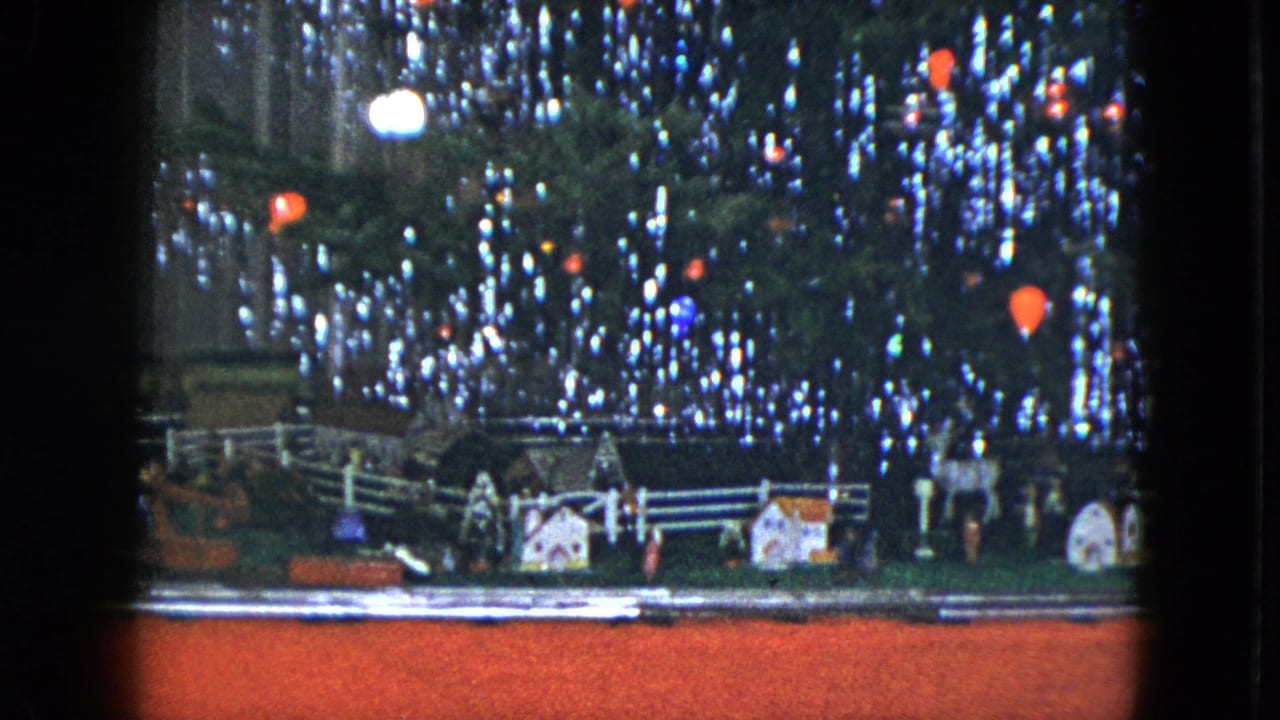 1951 Cleveland holiday display with a toy train track, small buildings, and a lit Christmas tree above.