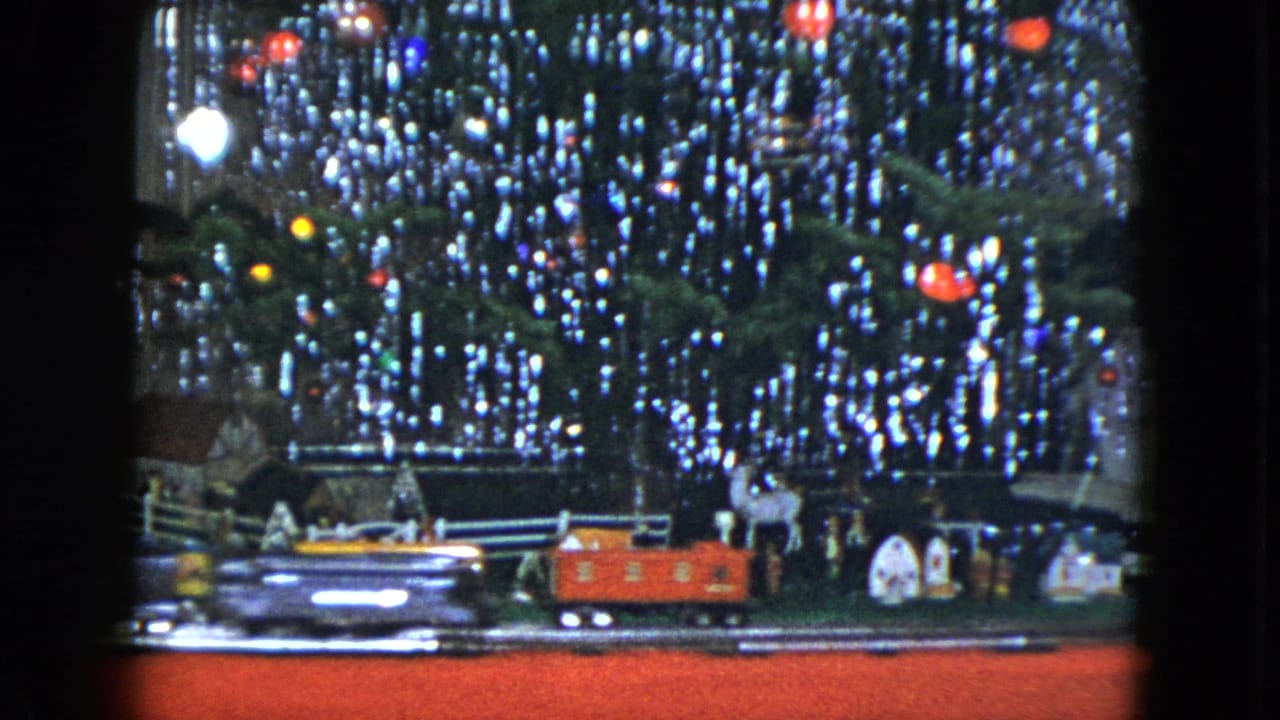 The Cleveland 1951 holiday display shows bright toy train cars moving past small houses, deer figures, and tree lights.