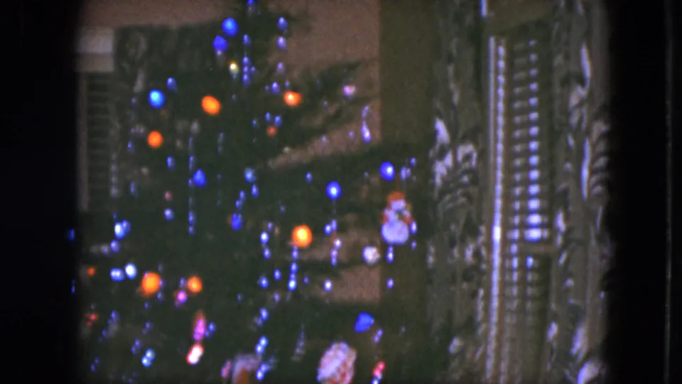 Final 1951 Cleveland frame showing a close Christmas tree view with blue and orange lights, small ornaments, and patterned curtains.
