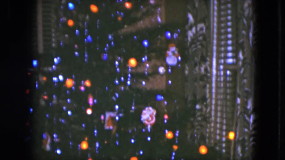 1951 Cleveland holiday interior with a softly focused Christmas tree, colored bulbs, ornaments, and shuttered windows.
