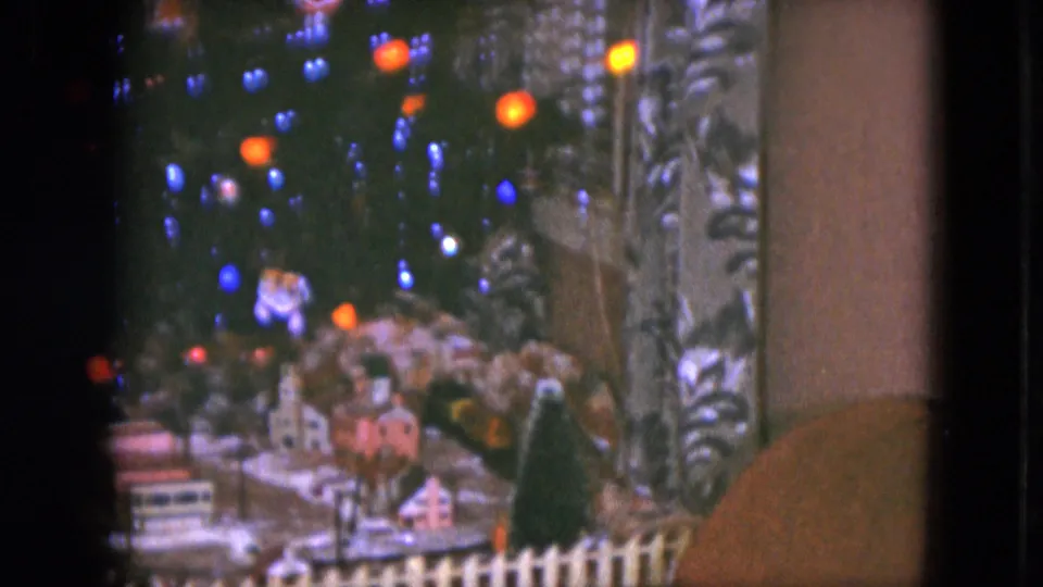 Soft 8mm frame of a decorated tree and small snowy village display, likely part of a Christmas train setup in Cleveland.