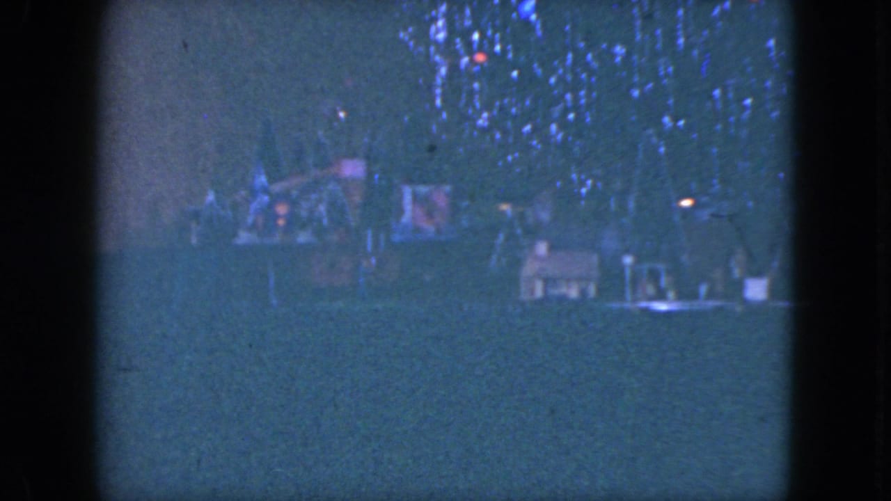Blue-tinted 8mm frame of a holiday tree and tabletop train layout, consistent with the 1951 Cleveland clip metadata.