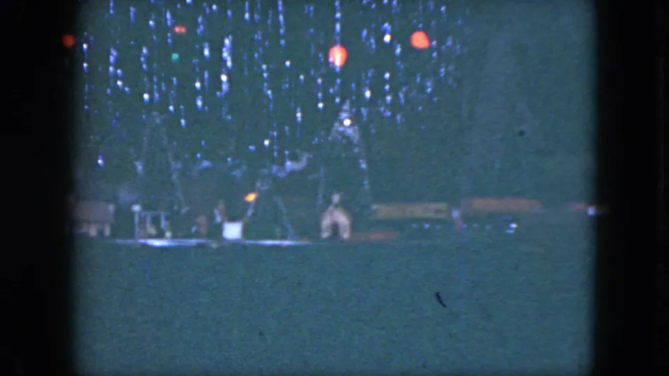 The Cleveland 1951 footage holds on a dim miniature train setup with small houses, trees, and red hanging lights.