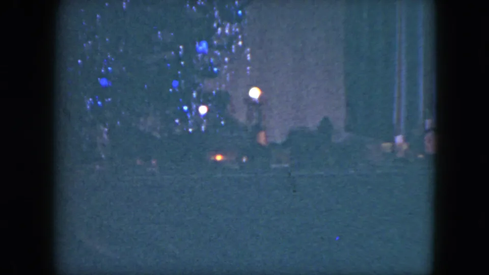 Soft 8mm frame from the Cleveland holiday scene with a toy train, glowing lights, and tinsel on the Christmas tree.