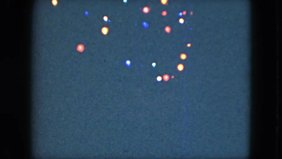 1951 Cleveland 8mm frame with red, blue, white, and amber lights clustered near the top of the night sky.
