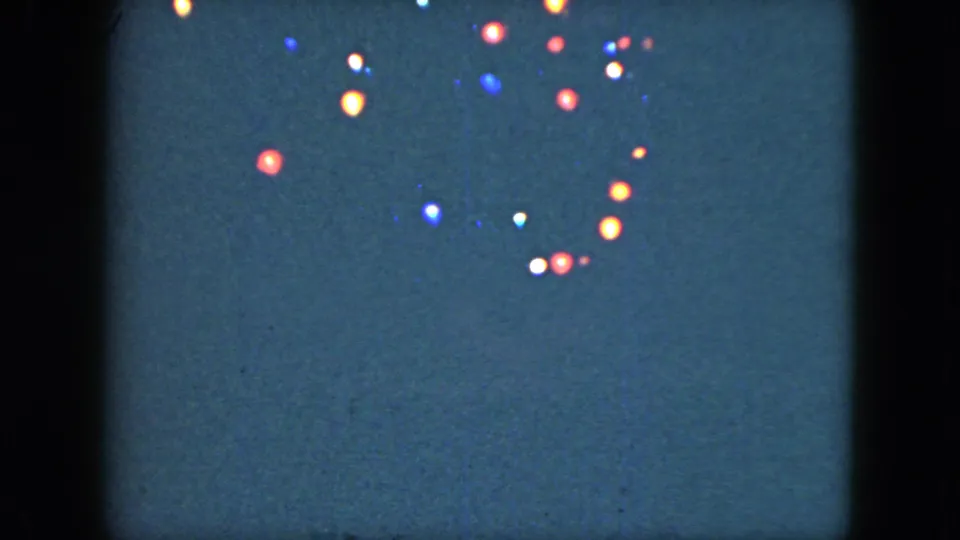 1951 Cleveland 8mm frame showing a denser spread of colored night lights and visible home-movie grain.