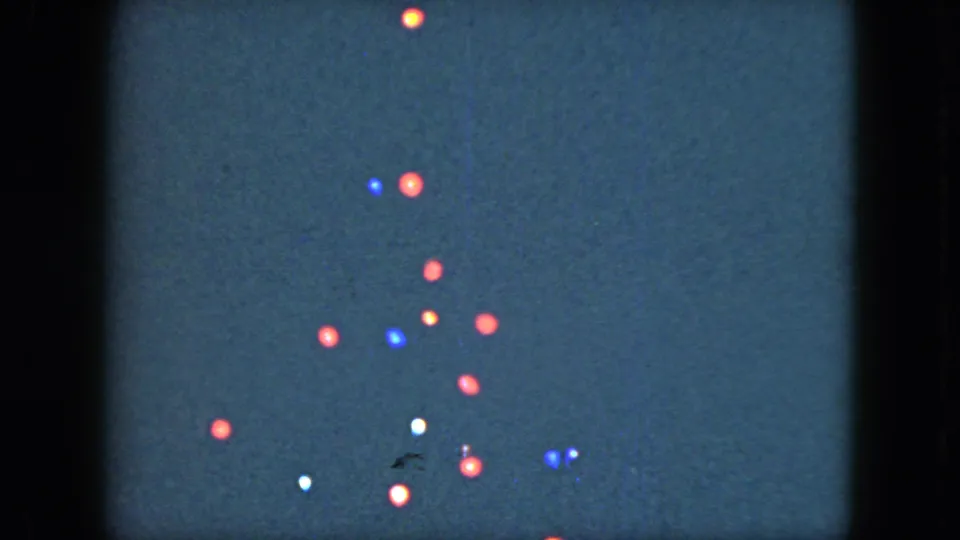 1951 Cleveland 8mm frame with red, blue, white, and amber lights shifted lower in the dark sky.