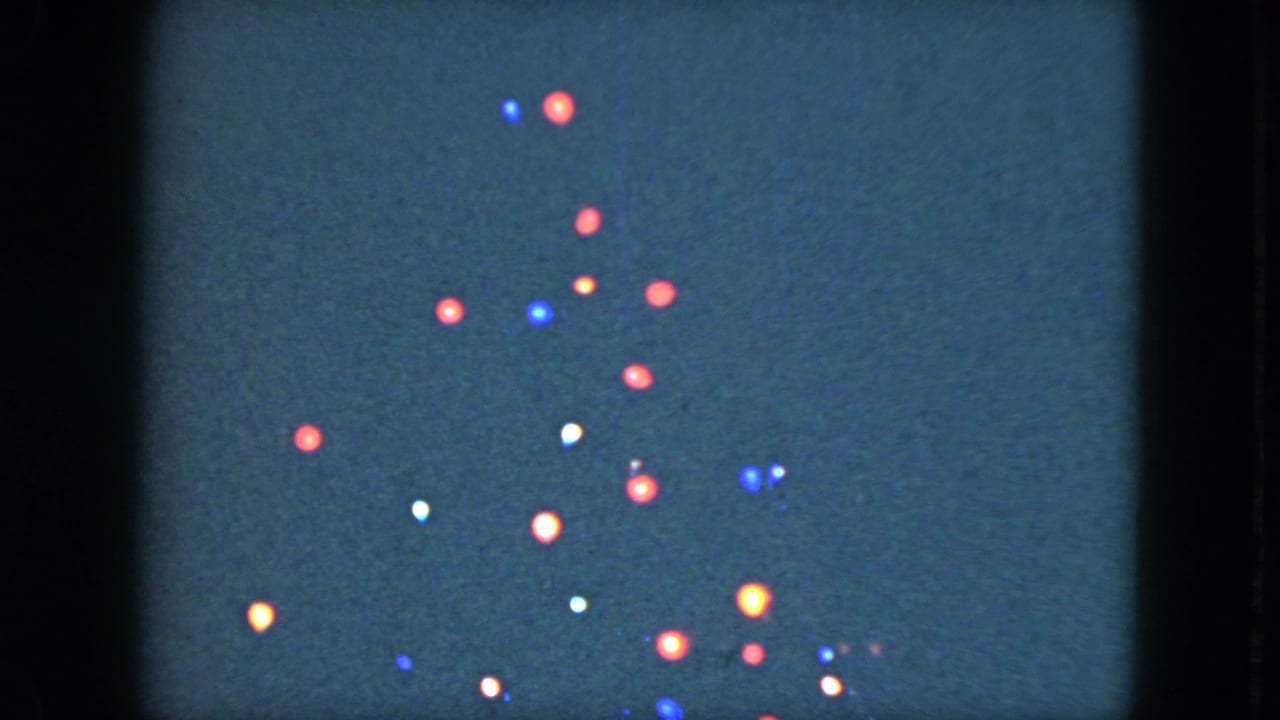 A denser cluster of colored bulbs appears on a dark night background.