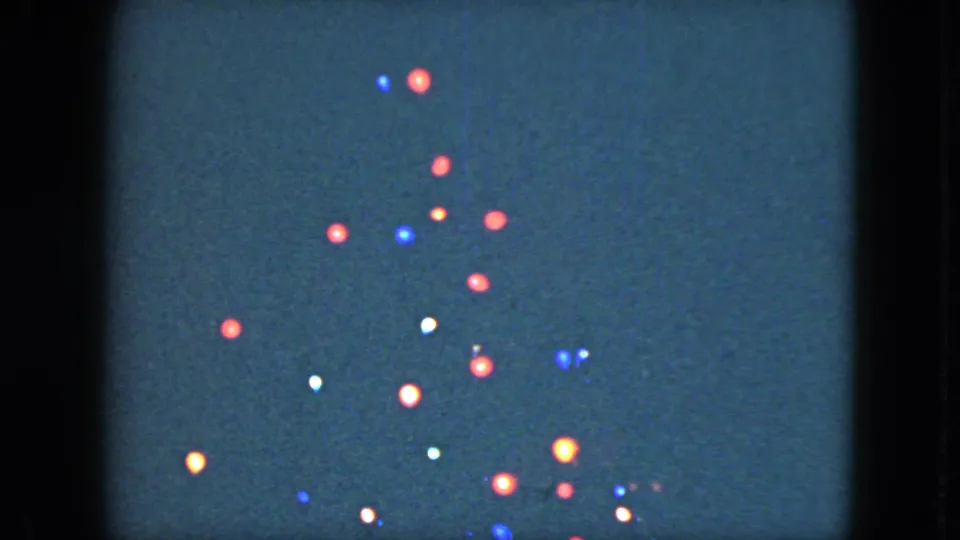 1951 Cleveland frame with clusters of red, blue, white, and amber holiday bulbs blooming softly on 8mm film.