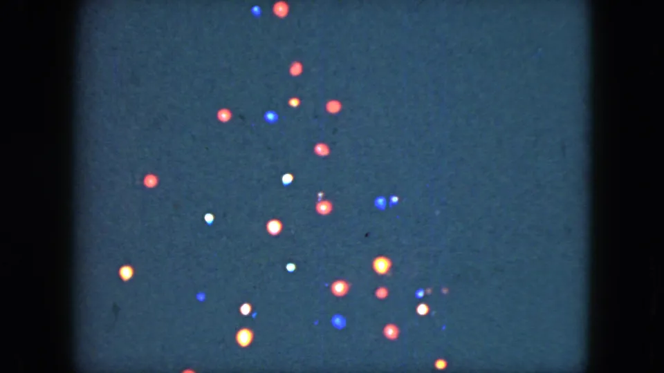 1951 Cleveland home-movie view of colored holiday bulbs arranged vertically, with soft focus and visible 8mm film texture.