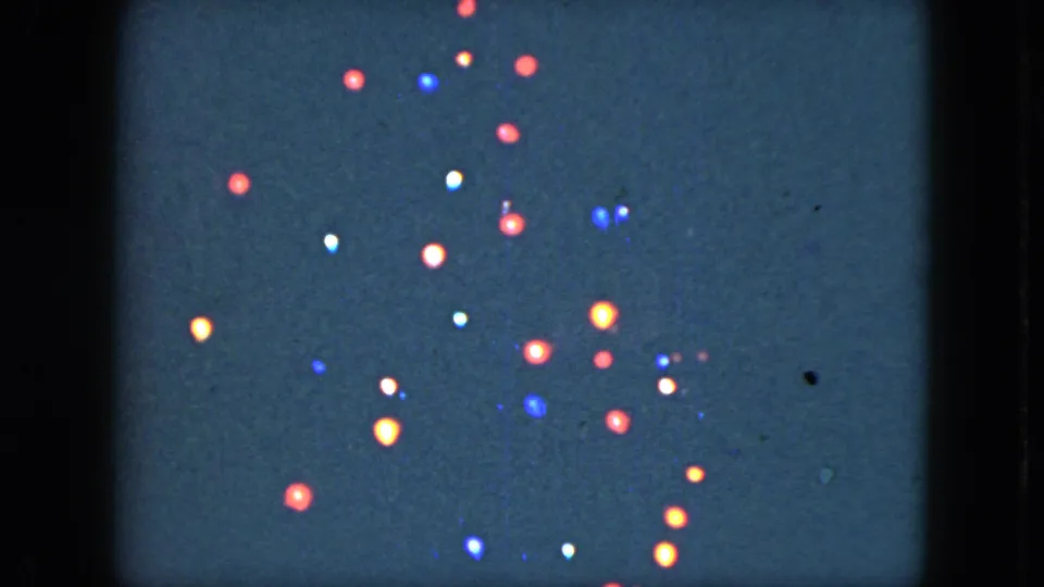 1951 Cleveland frame showing red, blue, white, and amber holiday lights scattered across a dark night field with film grain.