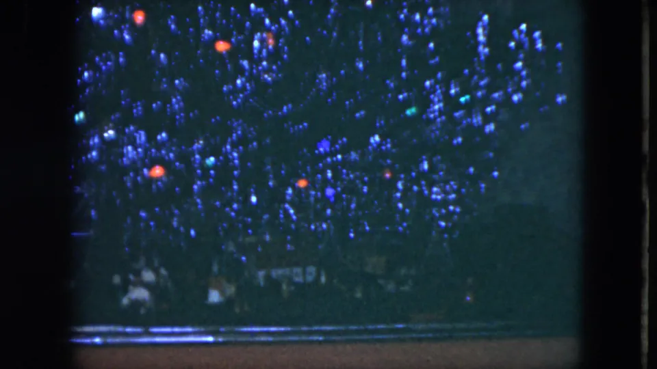 1951 Cleveland home-movie frame focused on colored lights above a dark piano area, with the performer no longer clearly visible.