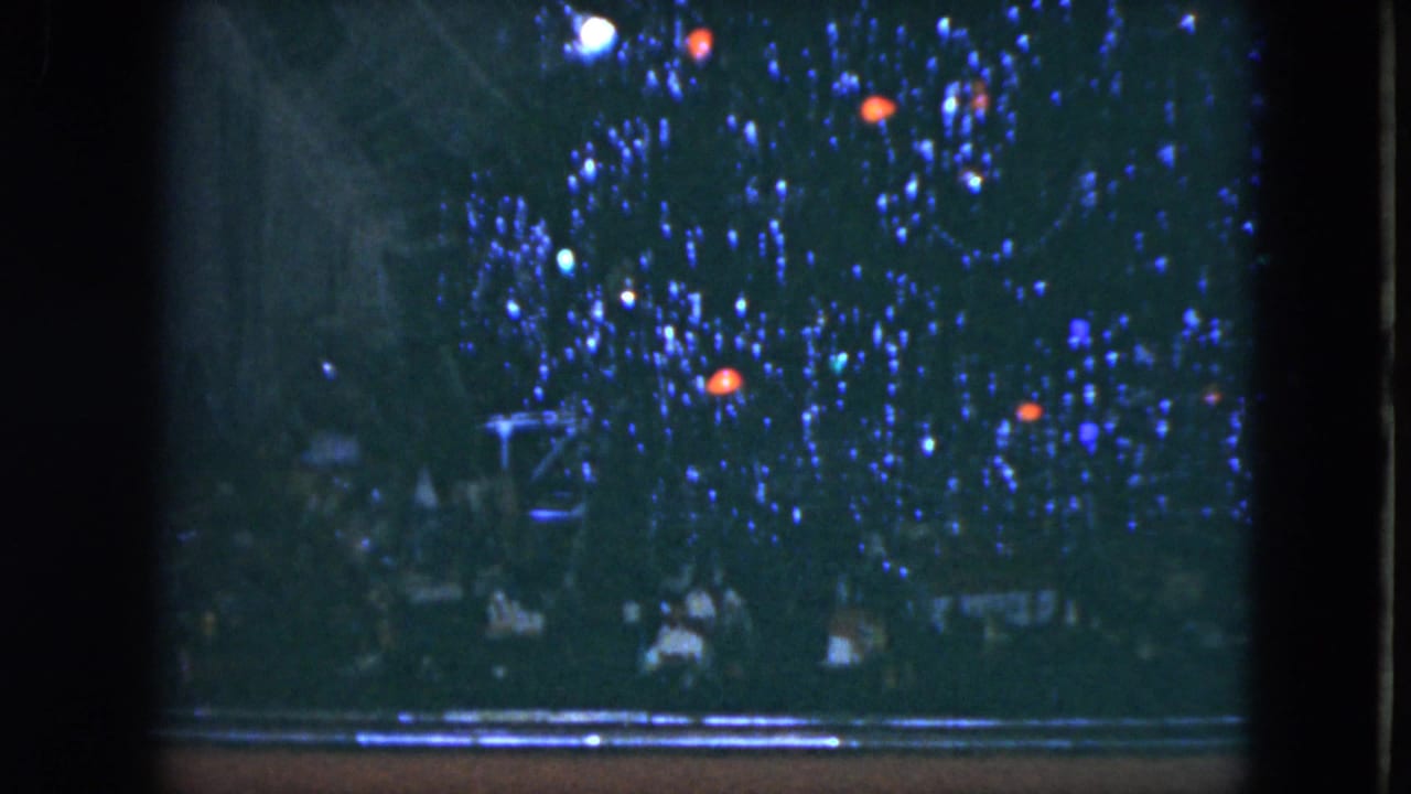 Blue-lit Christmas tree or display in Cleveland, Ohio, filmed in 1951 with dark frame edges and indistinct people near the bottom.