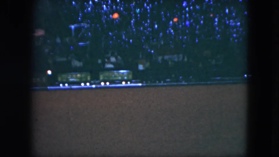 1951 Cleveland 8mm frame with train cars moving along tracks under a decorated Christmas tree.