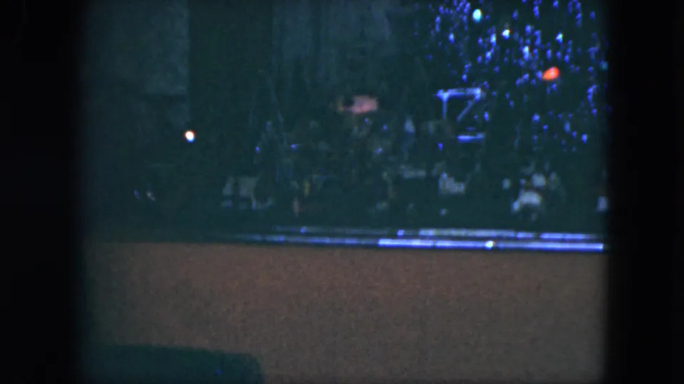 1951 Cleveland frame showing the end of the pan across a dim crowd and holiday-style lights in heavy grain.