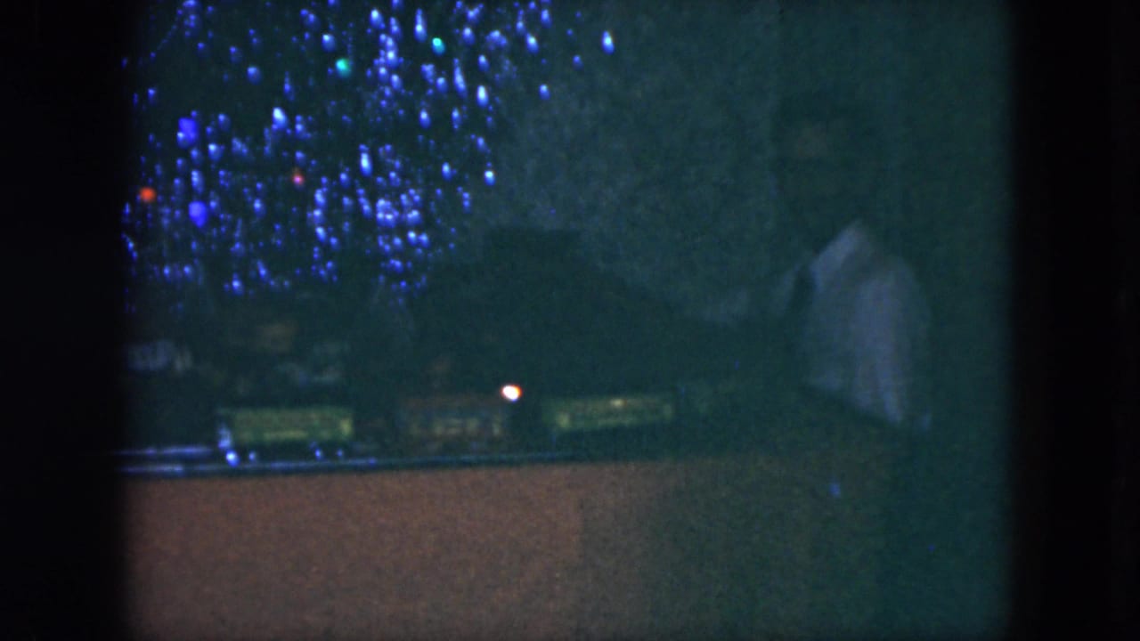 Miniature train display with blue lights and a person partly visible at right.