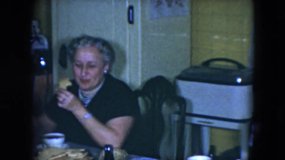Woman with styled hair eats at a kitchen table in Cleveland, Ohio, in 1951 home-movie footage.