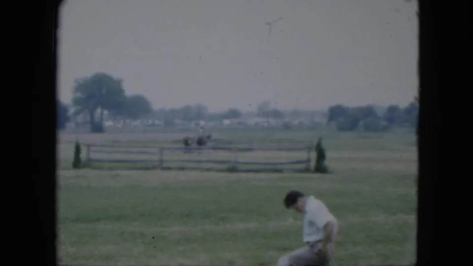 1951 Cleveland-area 8mm frame showing the man bending forward in the foreground with the horse and rider farther back.