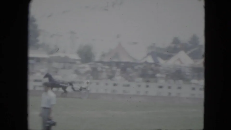 1951 Cleveland frame showing a horse and sulky on a grassy track while a man in a light shirt stands near the foreground.