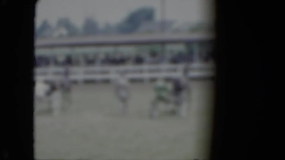 Soft 8mm frame from the Cleveland-area fairground scene with horses, small carriages, drivers, and spectators in the background.