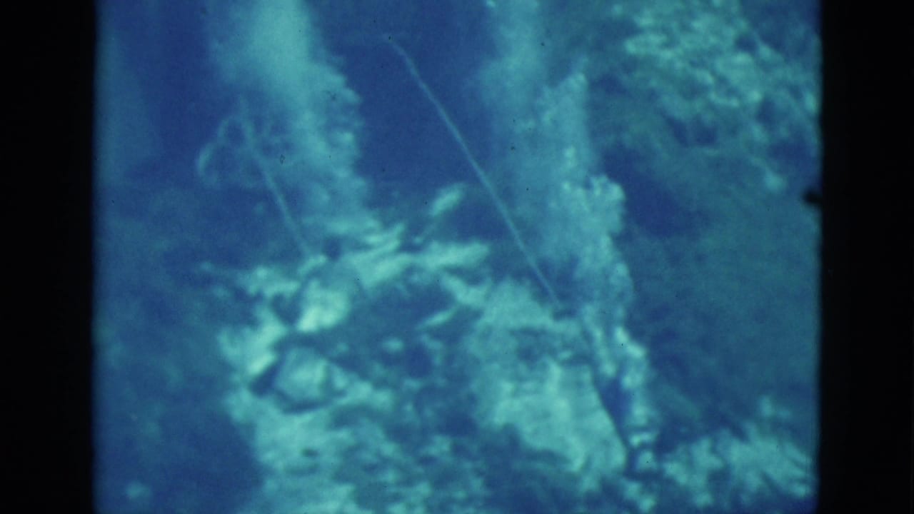 1952 Florida 8mm frame showing a blue underwater view with reef-like forms, a thin line, and indistinct sea life.