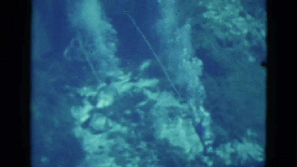 1952 Florida 8mm frame showing a blue underwater view with reef-like forms, a thin line, and indistinct sea life.