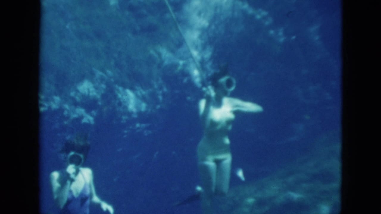 1952 Florida 8mm frame showing two women underwater with goggles and breathing tubes in clear blue-green water.