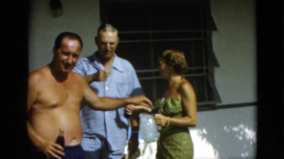 The closing frame shows adults socializing in 1952 Quebec, with a shirtless man smiling toward the camera as others stand nearby.