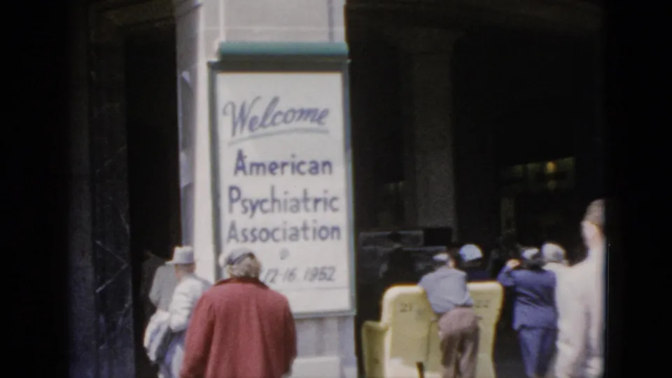 8mm color footage, Quebec 1952: mid-century-dressed attendees seen from behind approaching the APA conference building entrance, welcome sign and partial date visible.