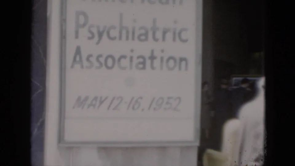 Close-up of conference signage with partially visible text at top edge possibly indicating the organization's full name; dated May 12–16, 1952; partial figure at lower right on 8mm film.