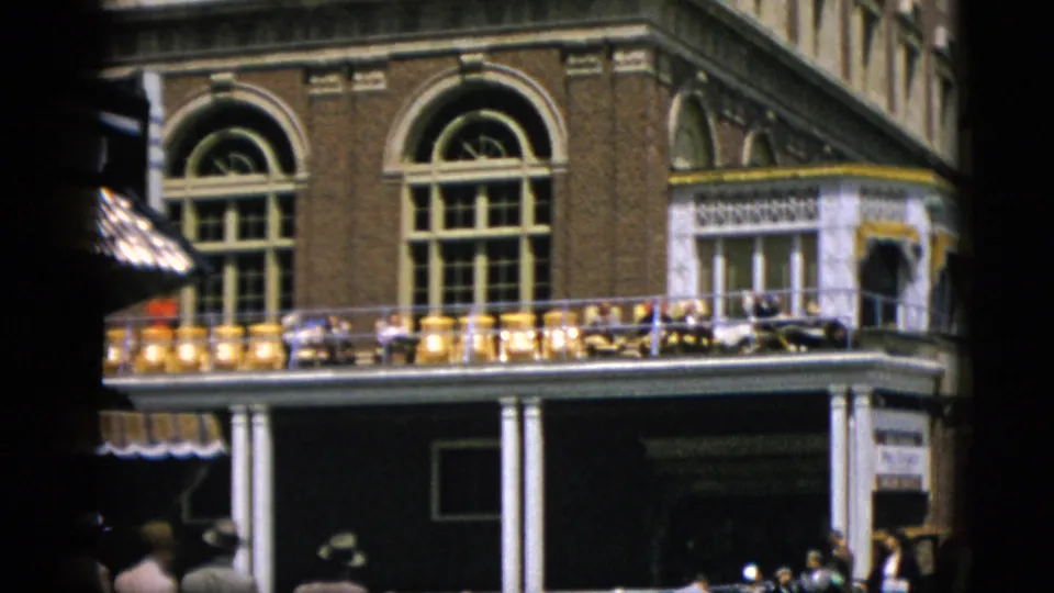 Detail shot of a prominent red-brick building with arched windows and colonnaded veranda, likely c. 1952 boardwalk architecture, Quebec, Canada.