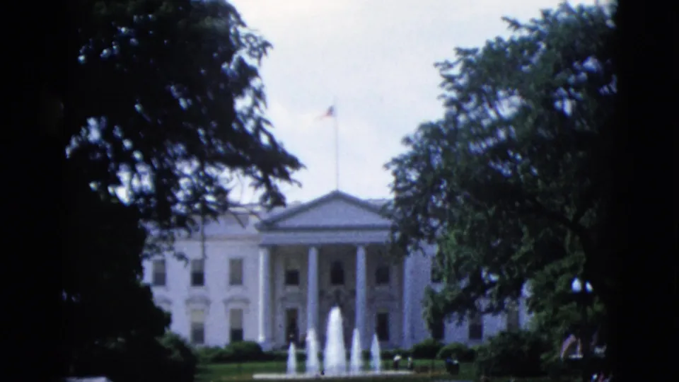 White House North Portico in Washington DC, circa 1952, with active north lawn fountains and tree foliage framing the left edge.