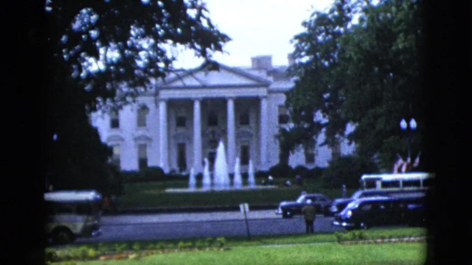 North Facade of the White House, Washington DC, circa 1952, with North Fountain active, a transit bus, dark sedans, and a pedestrian figure near the street.