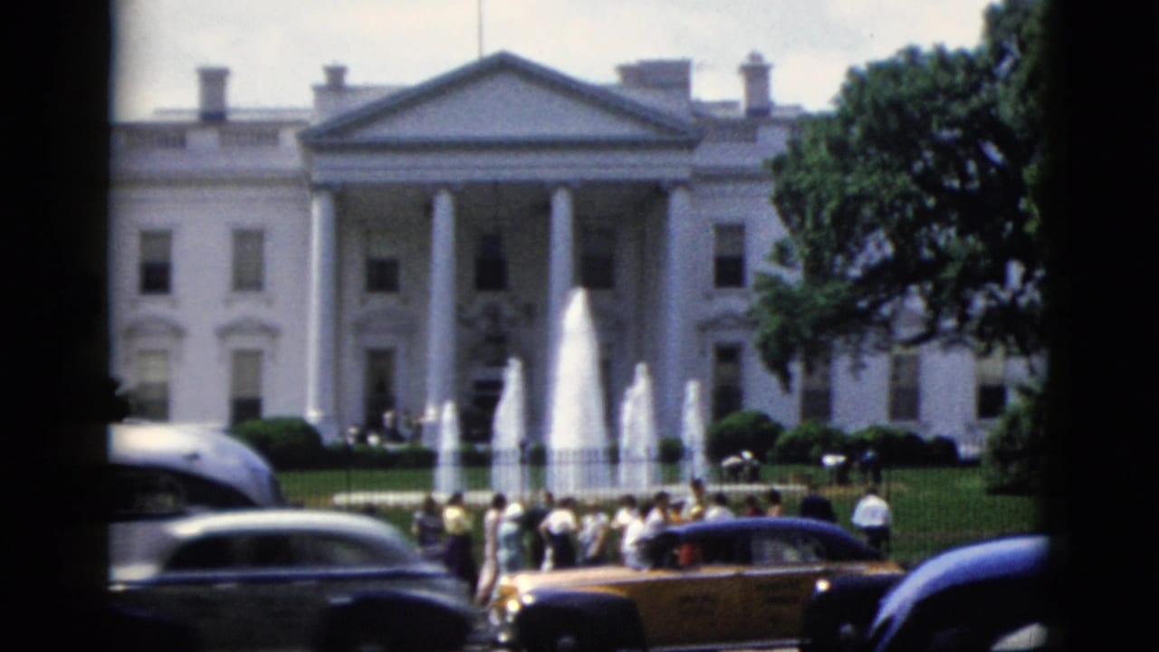White House north facade with active fountain and yellow taxi among early-1950s traffic, 8mm color film.