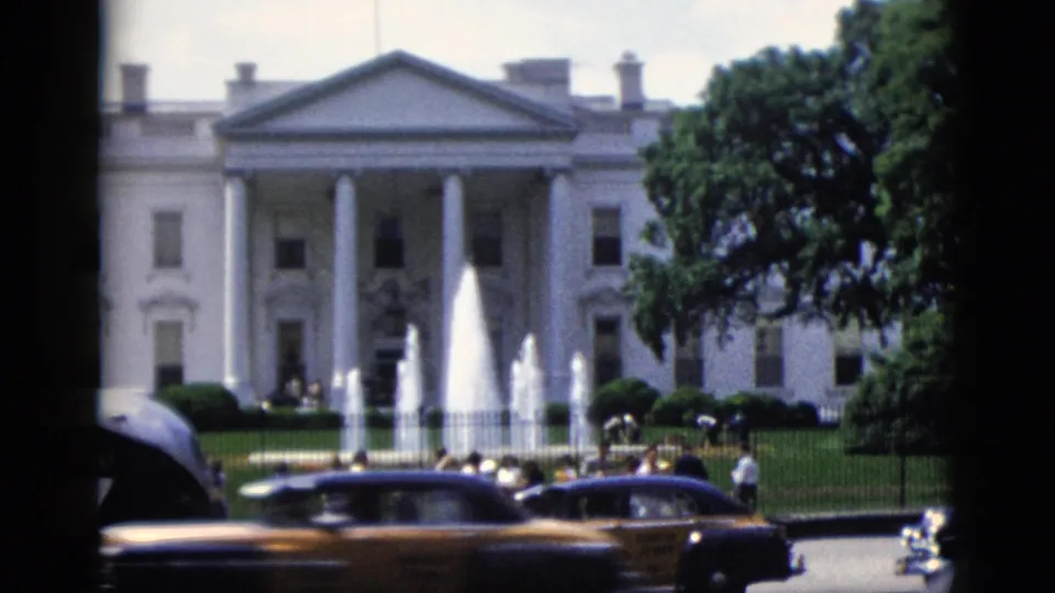 White House north facade, Washington DC, circa 1952 — fountain active, vintage automobiles including a yellow car, tourists visible near the perimeter fence, 8mm color home movie.