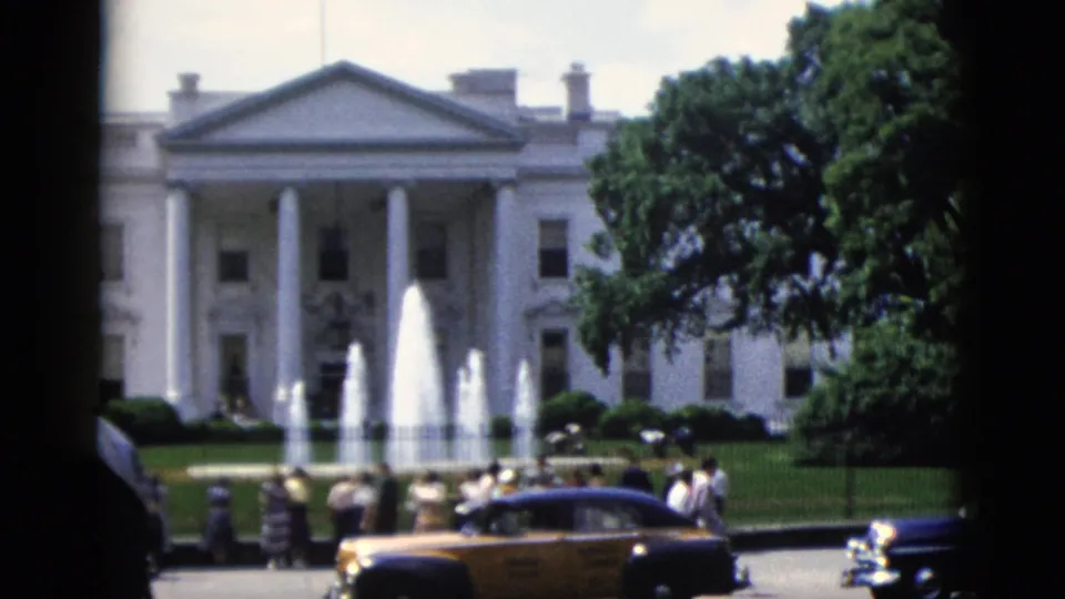 White House exterior with active fountain and early-1950s automobiles, Washington DC, circa 1952 — tourists and pedestrians along perimeter fence in 8mm color home movie footage.