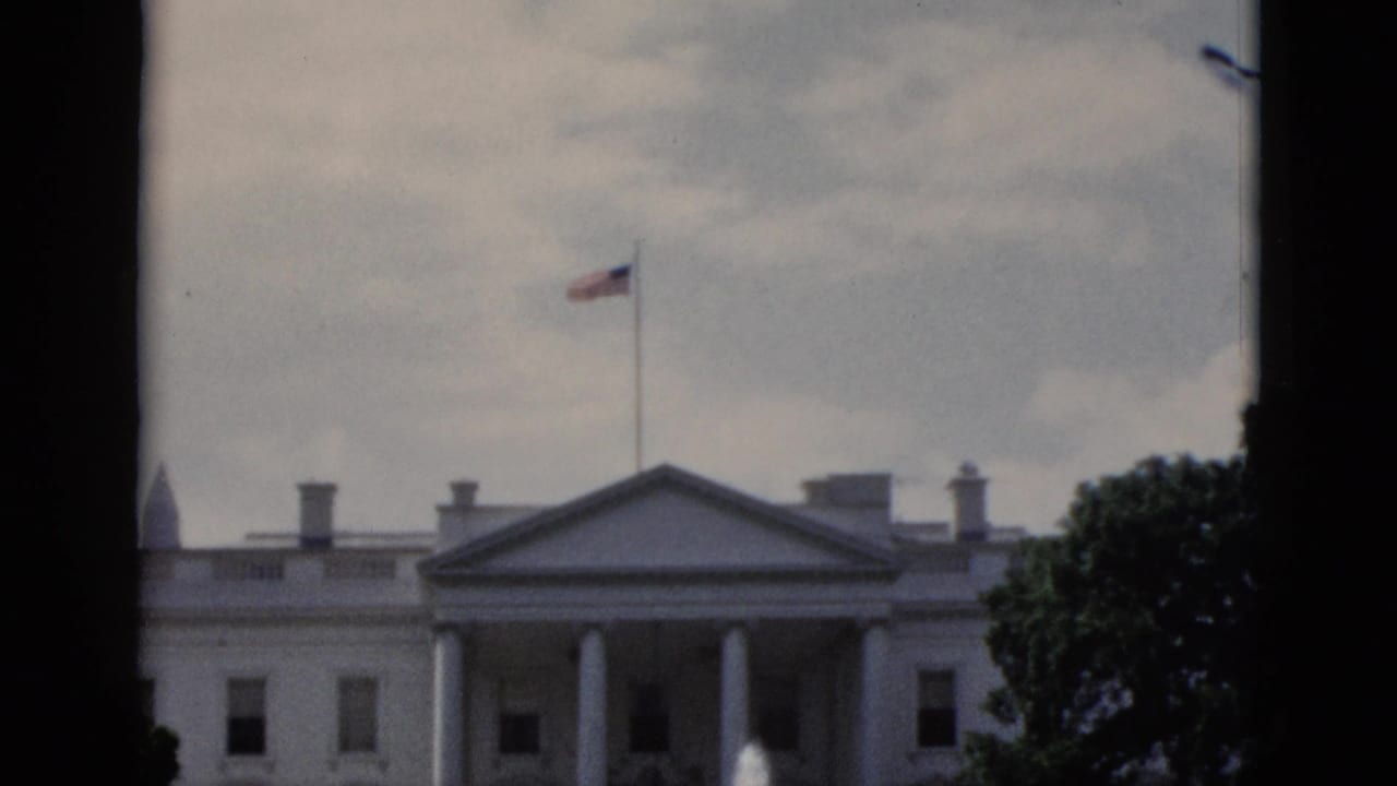 8mm tourist footage of White House north lawn, Washington DC, circa 1952: North Portico columns, fountain sprays, flag on roof flagpole, and grey overcast sky.