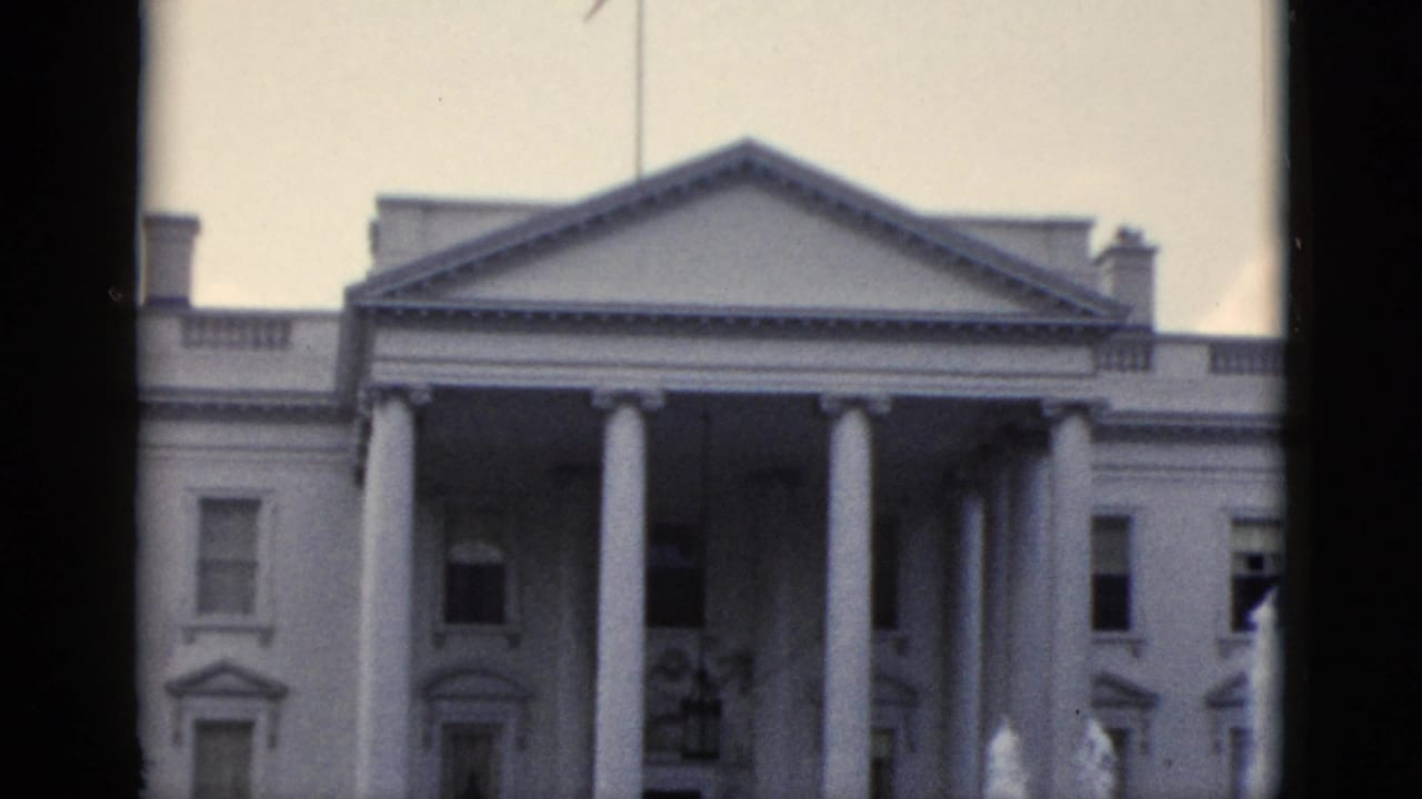 White House North Portico, Washington DC, filmed on 8mm in the early 1950s — columns, pediment, and flagpole visible against a pale overcast sky.