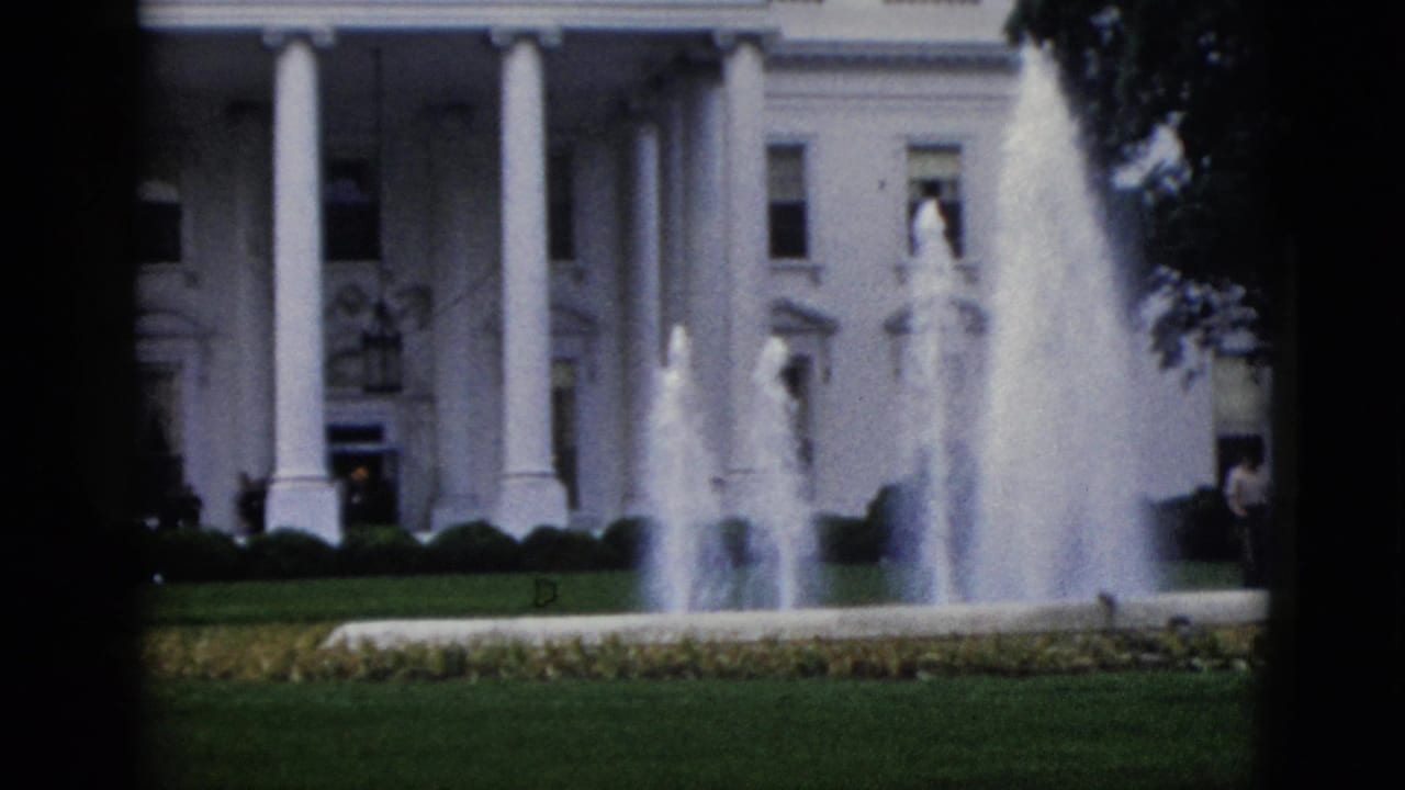 North portico of the White House, Washington DC, circa 1952, with twin fountains active and a flower-bordered lawn in the foreground, captured on 8mm home-movie film.