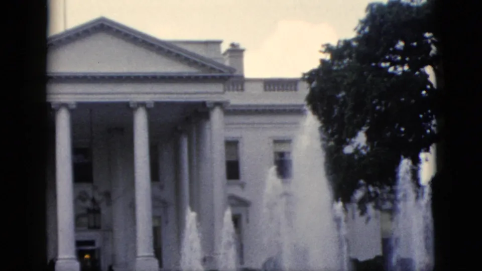 8mm home movie frame, c.1952, closer framing of White House north portico with active fountain jets and small figure near entrance.
