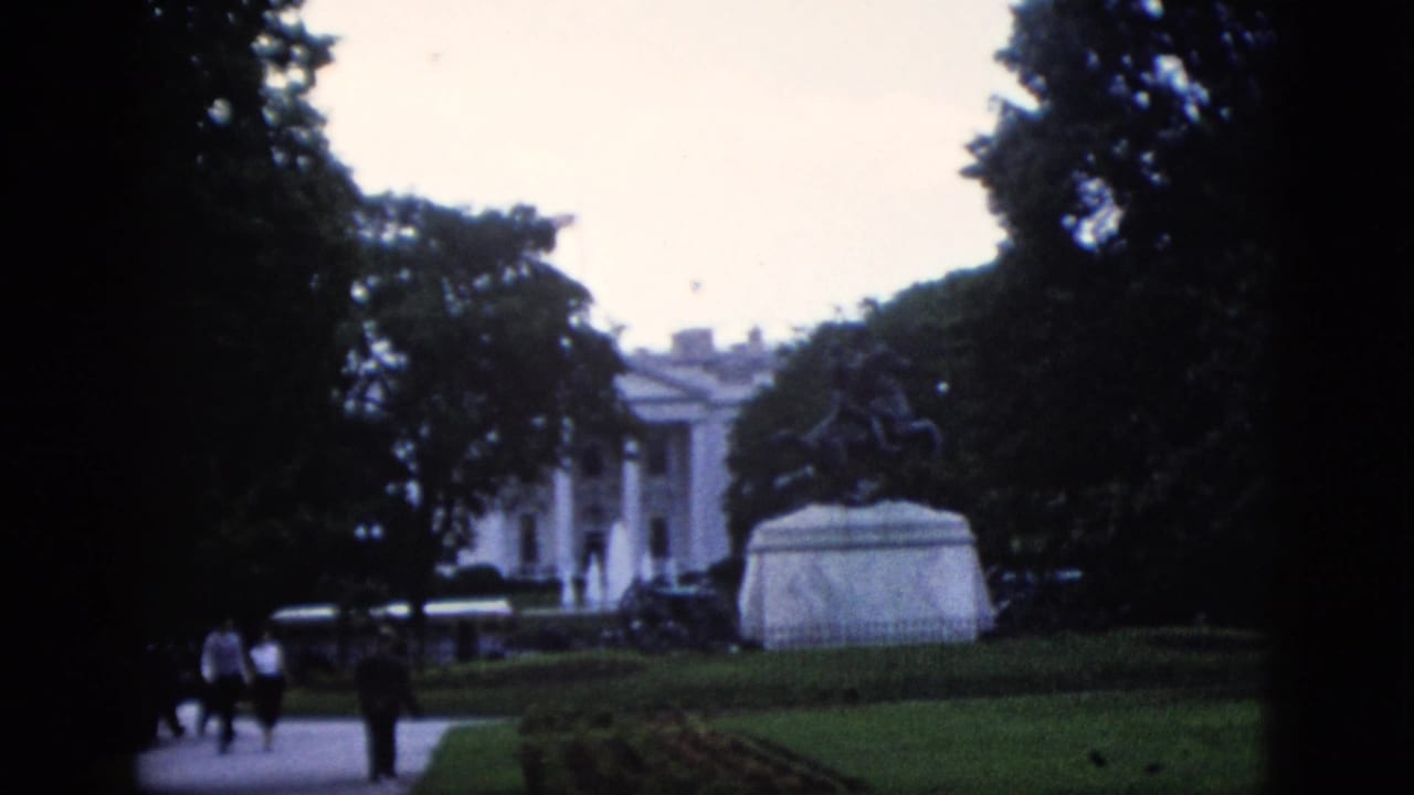 1952 8mm home movie view of the White House north portico with an equestrian statue in the foreground and visitors walking the path, Washington DC.