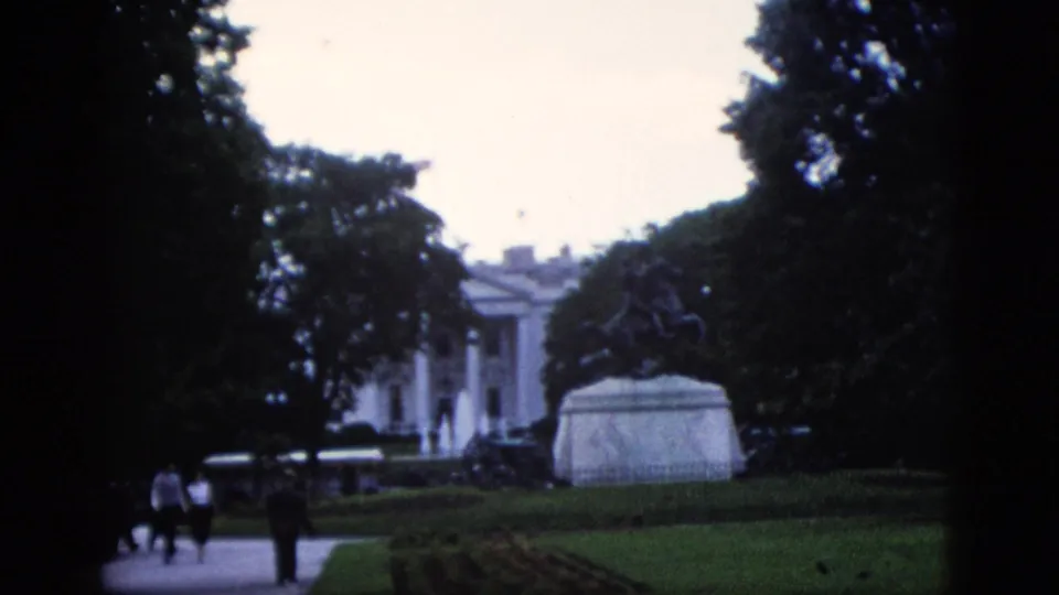1952 8mm home movie view of the White House north portico with an equestrian statue in the foreground and visitors walking the path, Washington DC.