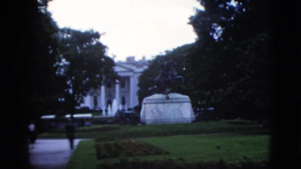 8mm color footage of the White House grounds with trees filling the frame and the equestrian statue pedestal in the foreground, Washington DC, circa 1952.
