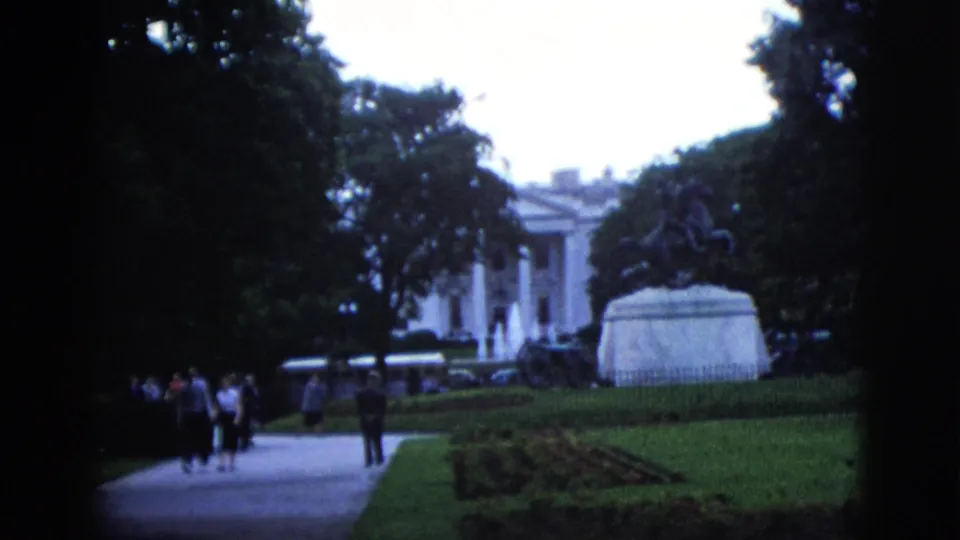 8mm home movie showing a group of visitors on the White House north grounds path, equestrian statue pedestal and building facade visible, Washington DC, circa 1952.
