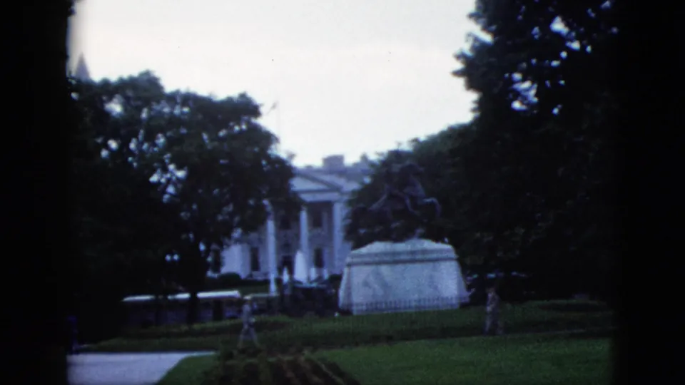 8mm home movie frame showing the White House north colonnade and equestrian statue, Washington DC, c.1952; a figure is visible near the statue base.