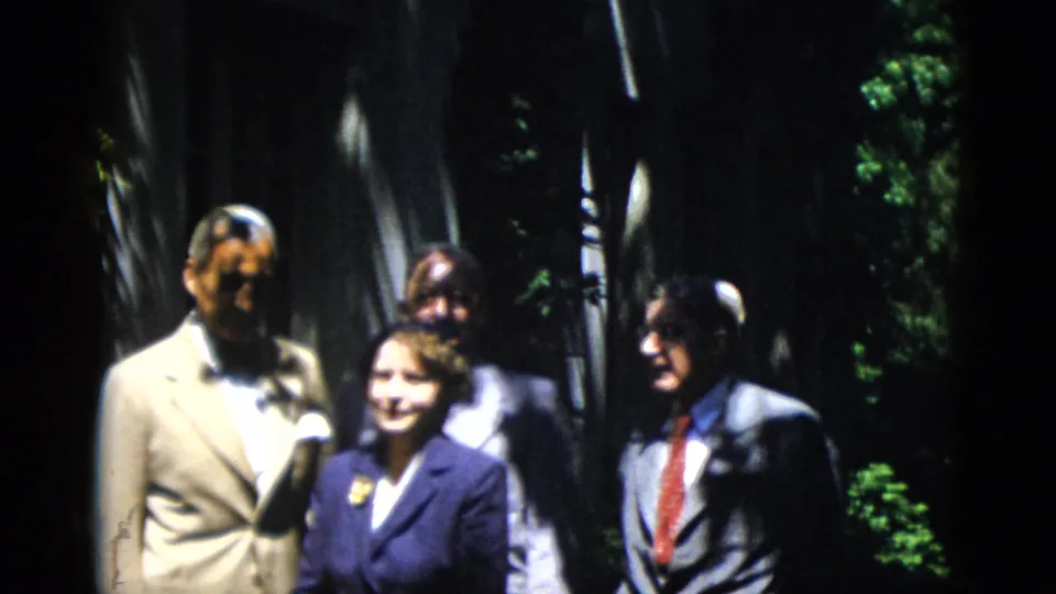 In 1952 Washington, DC home-movie footage, a formally dressed group stands outdoors as if posing for a photograph.