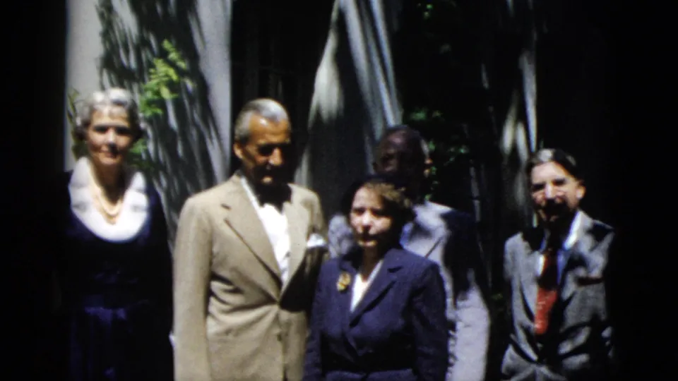 1952 Washington, DC 8mm frame showing relatives in suits and dresses posing outside a house entrance.