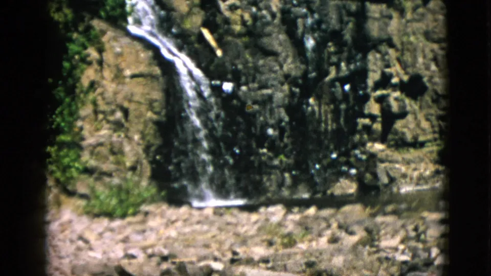 1952 Quebec 8mm frame showing the falls lower on the rock face, with a pale rocky stream bed below.
