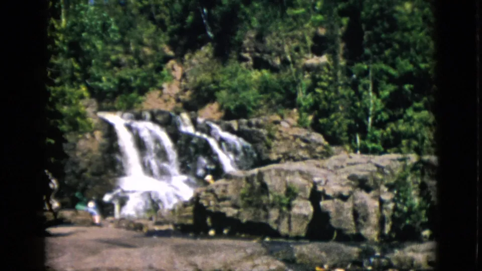 Final frame of a Quebec waterfall sequence circa 1952; a figure near the water's edge at lower right on warm-toned 8mm color stock.
